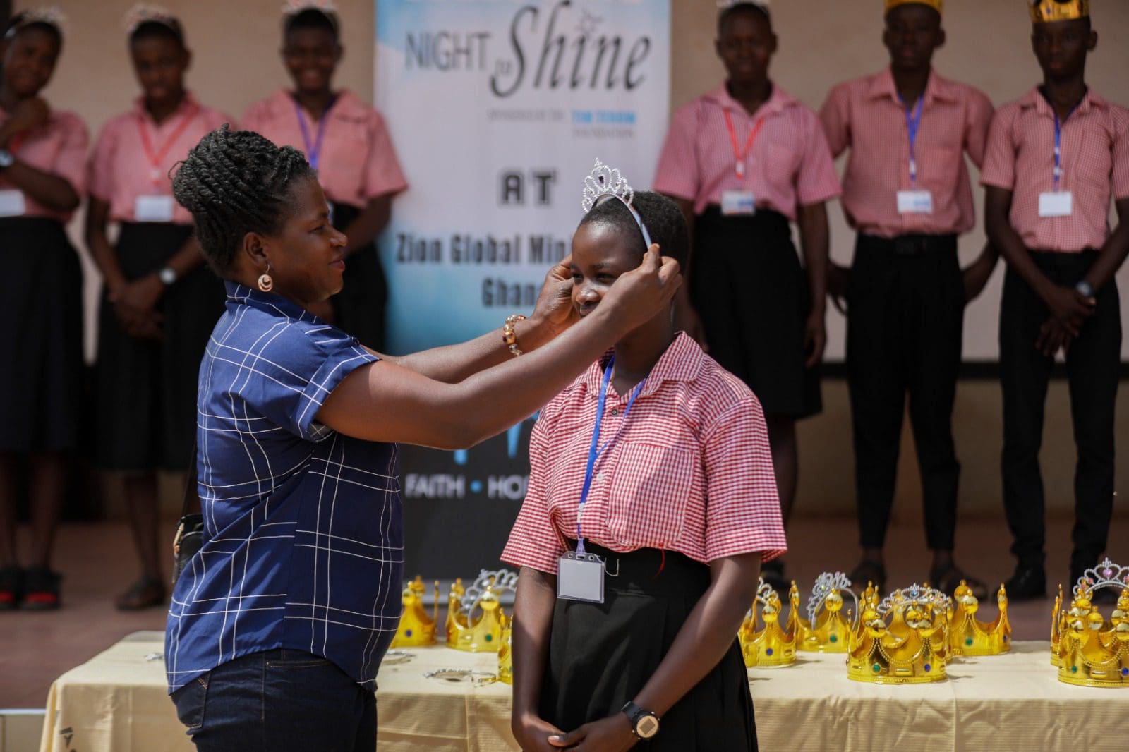 Woman crowning student at school award ceremony